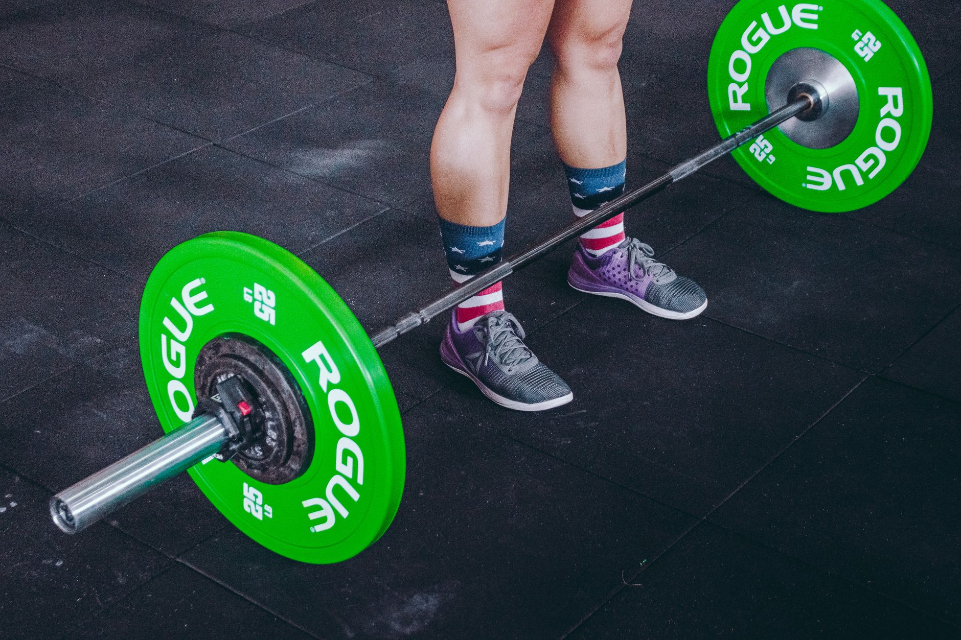 A lifter's legs and feet braced under a loaded barbell